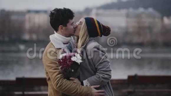 快乐的年轻夫妇在城市街道上接吻爱情关系浪漫的概念拍摄红色4K10位颜色视频的预览图