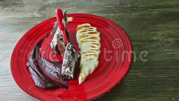 精致的装饰切片巧克力饼与烘焙奶油旋转在红色盘子视频的预览图