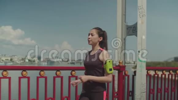 运动女子慢跑后在桥上快速行走视频的预览图