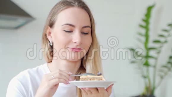 年轻漂亮的女人带着蛋糕特写肖像坐在家里视频的预览图