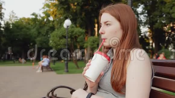 红发女孩在公园里喝咖啡视频的预览图