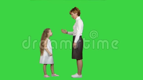 美丽的母亲和女儿在绿色的屏幕上互相微笑Chroma键视频的预览图
