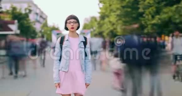 站在城市街道上背包的年轻女游客的时光流逝画像视频的预览图