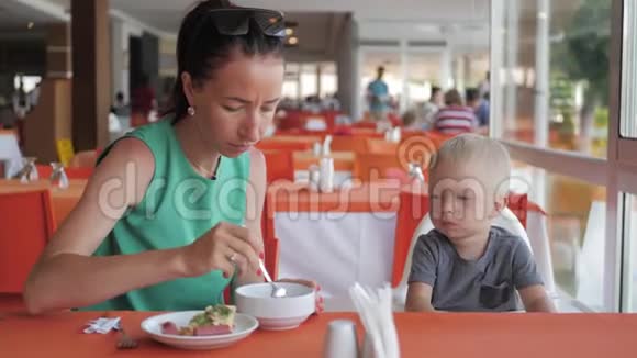 妈妈正在咖啡馆里喂小儿子吃早餐视频的预览图