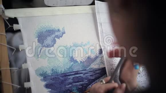 爱好和体力劳动一位白种人妇女在刺绣机上绣一个十字绣并画了一个刺绣品视频的预览图