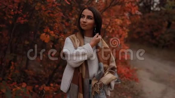 女人享受秋天的日子她走在森林里四周有五颜六色的叶子动作缓慢视频的预览图