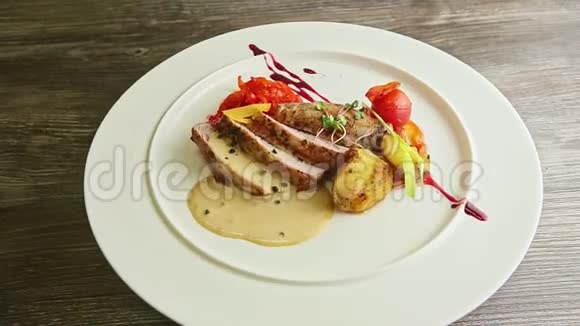 装饰时髦的切片烤肉和蔬菜在盘子上旋转视频的预览图