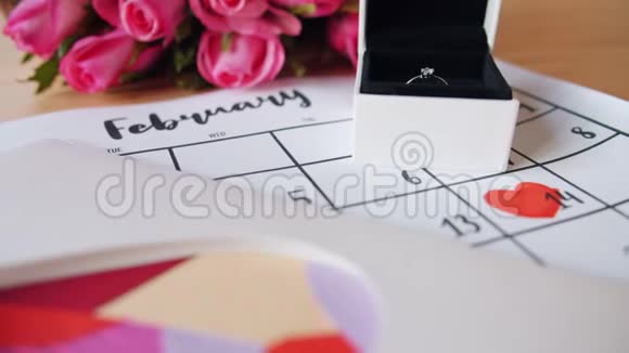 用鲜花戒指卡片和日历庆祝情人节美丽的节日视频的预览图