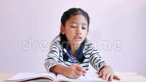 亚洲小女孩用铅笔在笔记本上画东西视频的预览图