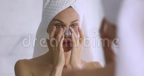 微笑的女人涂鼻带清洁毛孔照镜子视频的预览图