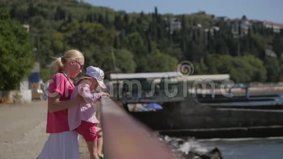 母女俩站在水边眺望大海倚在篱笆上视频的预览图