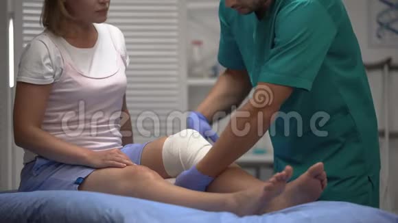 骨科医生从女性患者腿上取出弹性膝包康复视频的预览图