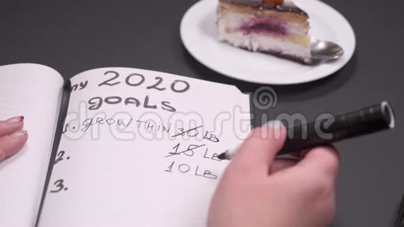 特写女人的手写目标列表黑桌子上的笔记本顶部视图视频的预览图