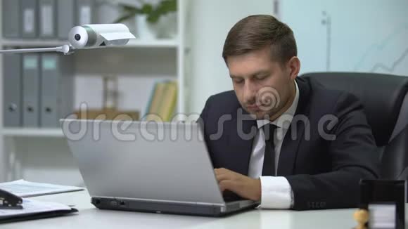 昏昏欲睡的商人在笔记本电脑上打字打哈欠工作过度视频的预览图