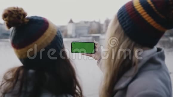 年轻漂亮的女士带着智能手机少年女孩的特写镜头她手里拿着一部智能手机白色的绿色隔离开来视频的预览图