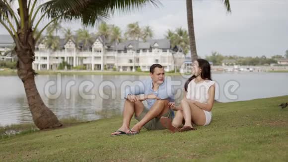 休息夫妇在度假村坐在草坪上享受旅程视频的预览图