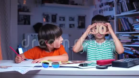 两个快乐的男孩坐在桌子旁一个画画然后显示字母视频的预览图