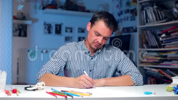 坐在桌旁的疲倦的人写字摸他的头视频的预览图