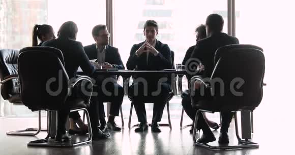 自信的商人在会议桌上与各种商人交谈视频的预览图