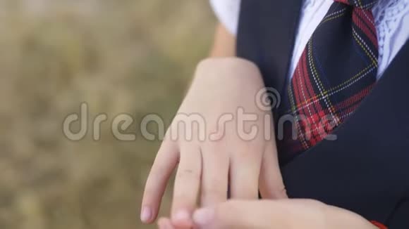 穿校服的小女孩吹在手背上的伤口上视频的预览图