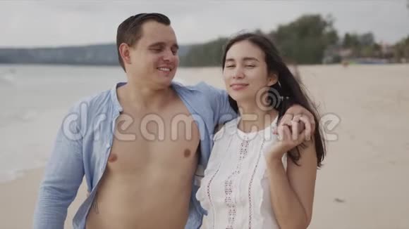 快乐的恋人旅行者拥抱异国情调的海滨微笑视频的预览图