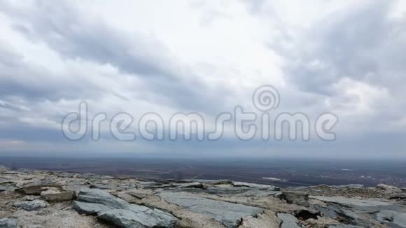前景中的平原和石墙上方云层的时间流逝视频的预览图