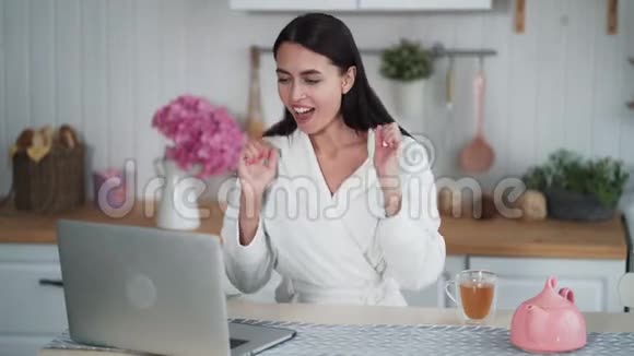 年轻女性在笔记本电脑上工作在电子邮件中获得积极消息感到快乐兴奋视频的预览图