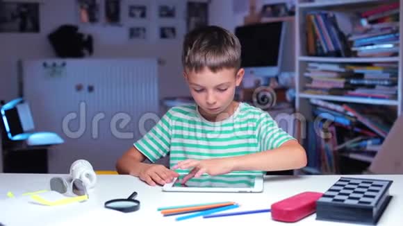 有平板电脑的男孩坐在学校的桌子旁做运动视频的预览图