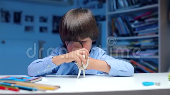 一个穿着蓝色衣服的孩子坐在桌子旁检查动物的骨头视频的预览图