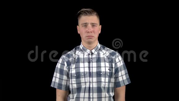 年轻人在哭情绪激动的男人在黑色背景下哭泣视频的预览图