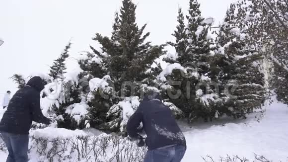 两个年轻的白种人在冬天胡闹打雪球冬天的天气慢动作视频的预览图
