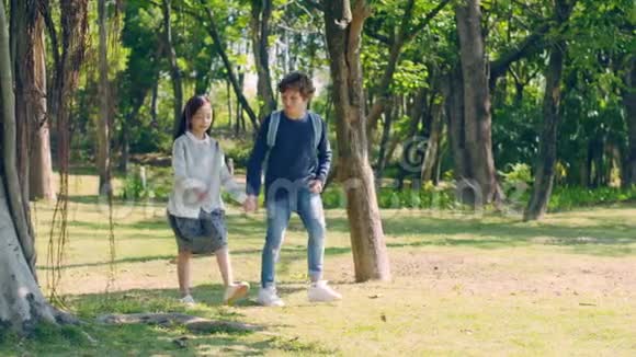亚洲小女孩和高加索男孩在公园散步视频的预览图