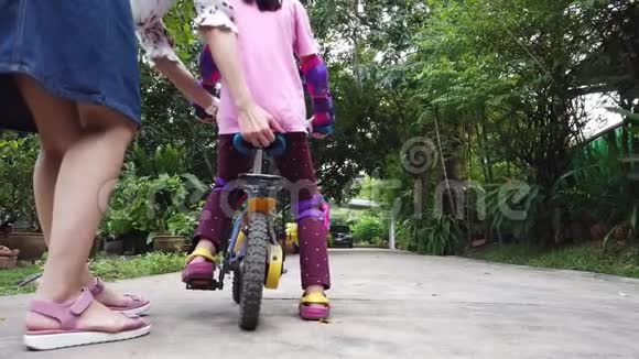 妈妈在教她的女儿骑自行车视频的预览图