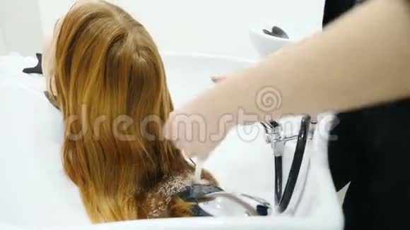美和发型的概念理发师洗女姜发特写镜头让她的头发洗进去视频的预览图