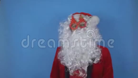 戴着圣诞眼镜戴着圣诞树的胡子圣诞老人在蓝蓝的相机上翩翩起舞视频的预览图