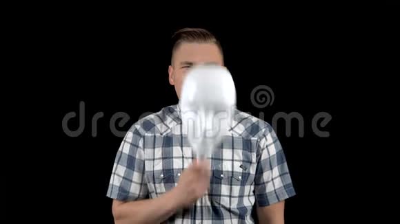 一个年轻人摘下面具脸上流露出情感穿衬衫的愤怒男人一个人把脸藏在白色的后面视频的预览图