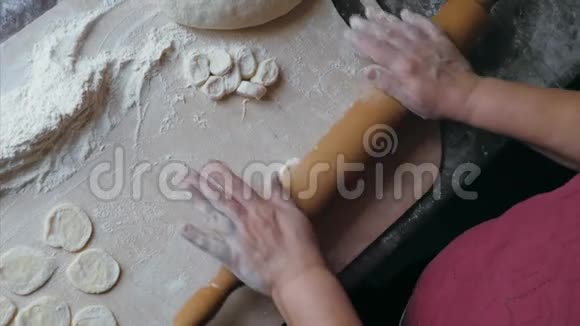 在家厨房里高级女性的特写手在擀面包饺子视频的预览图