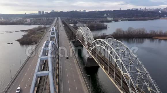 从基辅城市天际线上方俯瞰达尼茨基汽车和铁路大桥横跨第聂伯河视频的预览图