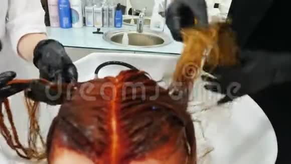 女性美的概念理发店的彩色师和助理染色和着色客户头发美容师用染料视频的预览图