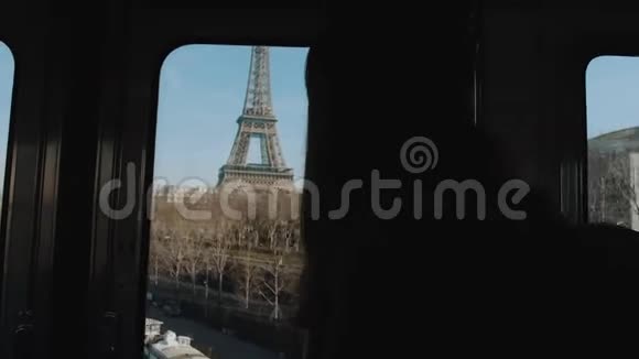 巴黎乘地铁列车的年轻女子剪影看着窗外的埃菲尔铁塔和塞纳河视频的预览图