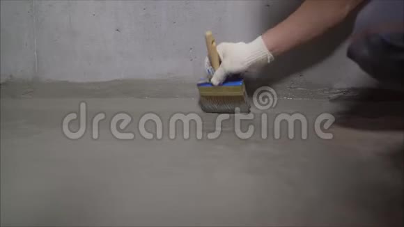 工人用刷子润湿混凝土地板用毛刷湿润混凝土地面地板防水准备阶段视频的预览图