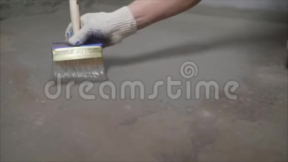 工人用刷子润湿混凝土地板用毛刷湿润混凝土地面地板防水准备阶段视频的预览图