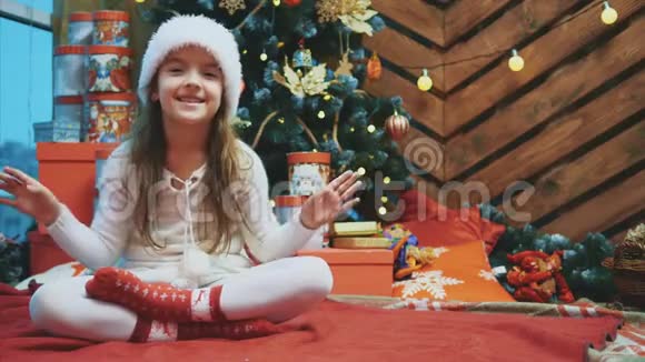 4K视频年轻女性戴着圣诞帽挥舞着手邀请每个人与她在木制背景下庆祝视频的预览图