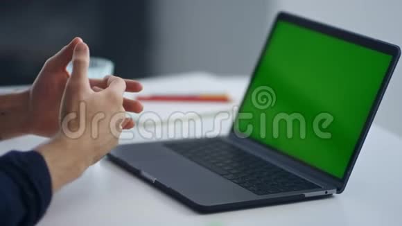 特写商人在视频会议上讲话一个绿色屏幕笔记本电脑视频的预览图