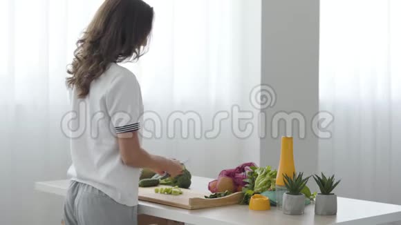 技能女孩在家中站在厨房的一张桌子旁用刀切黄瓜熟练的厨师准备早餐视频的预览图