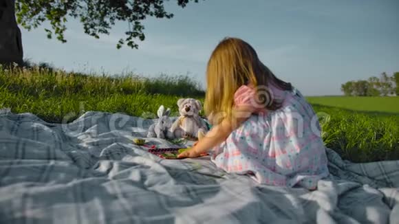 小女孩正在草地上玩玩具用具和玩具视频的预览图