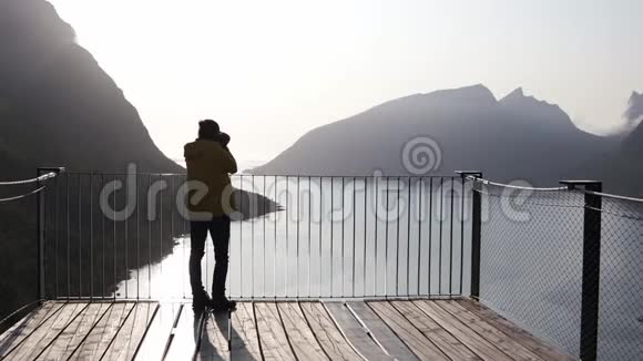 一位女士用数码单反相机从一个角度拍摄挪威峡湾视频的预览图
