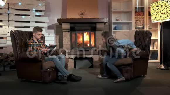 哥哥和妹妹在舒适的大客厅的壁炉旁自由活动视频的预览图