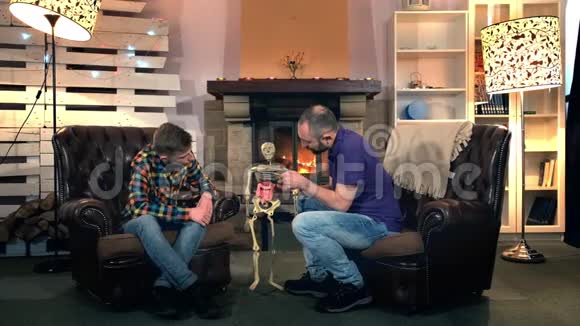 父亲解释了他的大儿子骨骼上的人体结构视频的预览图