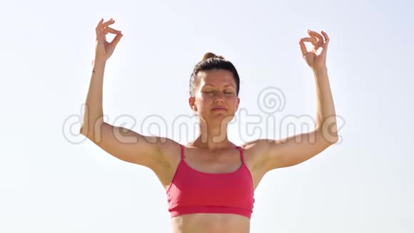 低角度弧形拍摄的女人做放松瑜伽与山脉背景视频的预览图